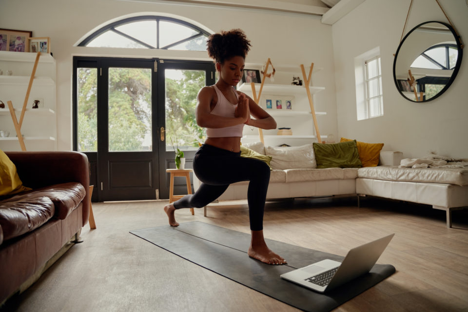 Healthy woman doing yoga in home by Degree Residential