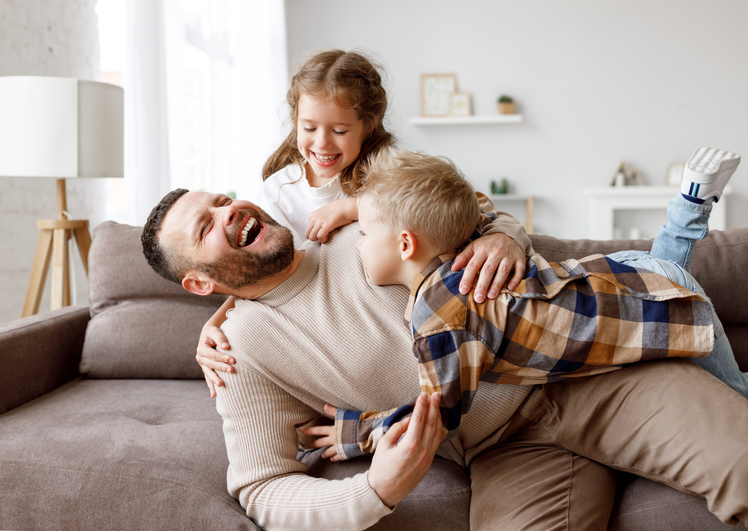 father enjoying time with kids with heat pump in home