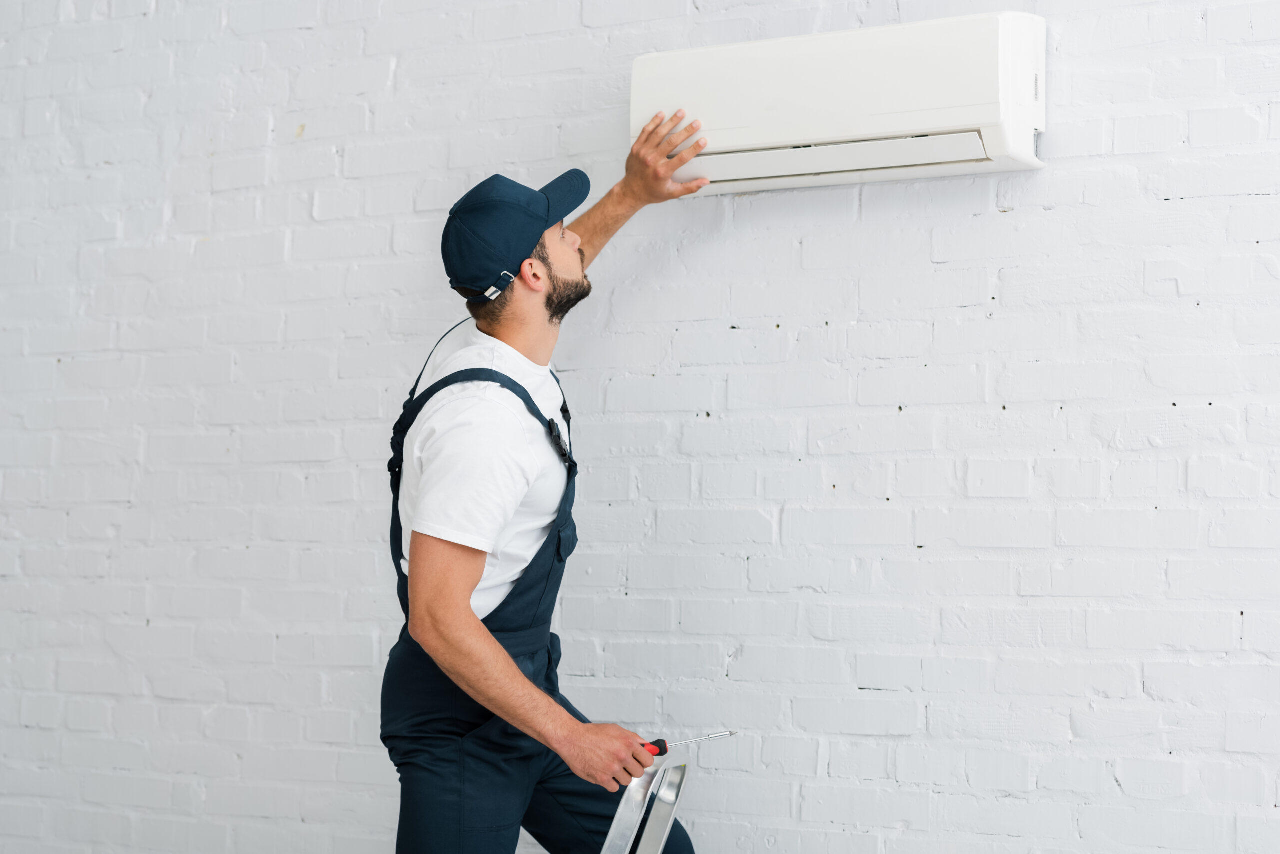 man performs summer hvac maintenance